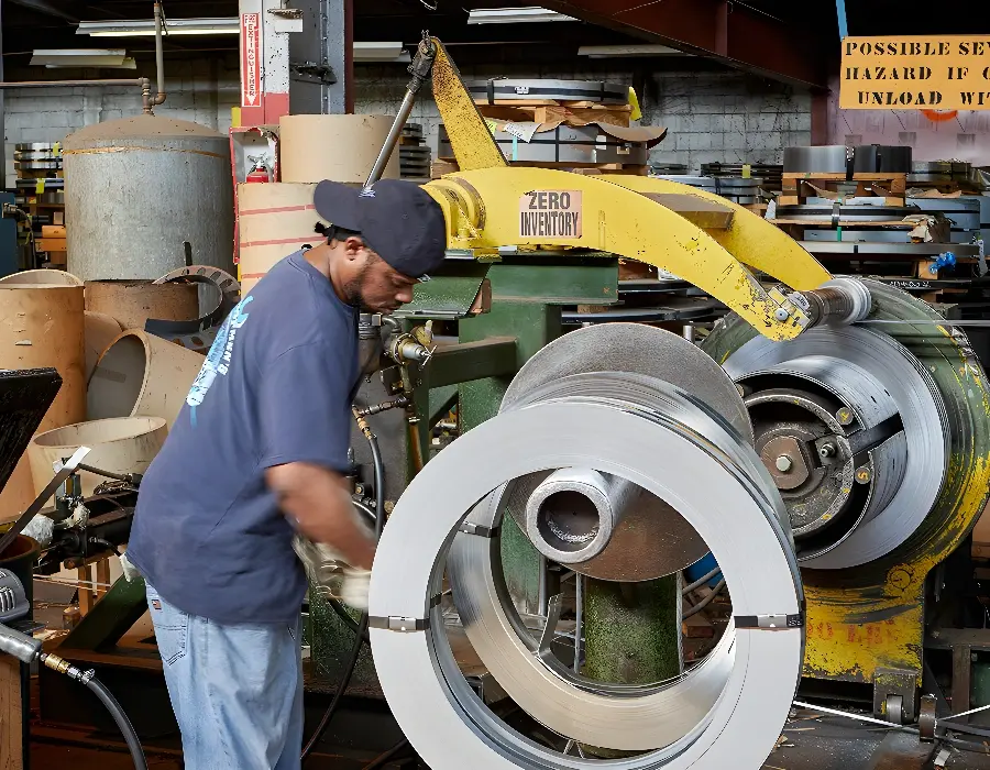 Worker processing galvannealed steel coil at a steel service center